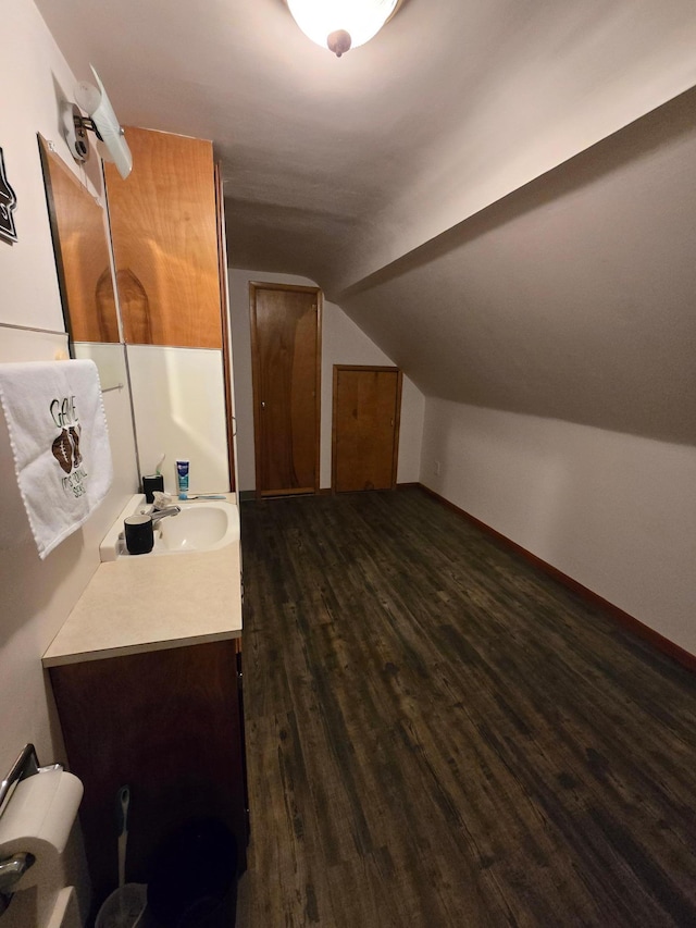 1014 3rd Ave SW, Pipestone, MN 56164 - bathroom featuring baseboards, vanity, wood finished floors, and lofted ceiling