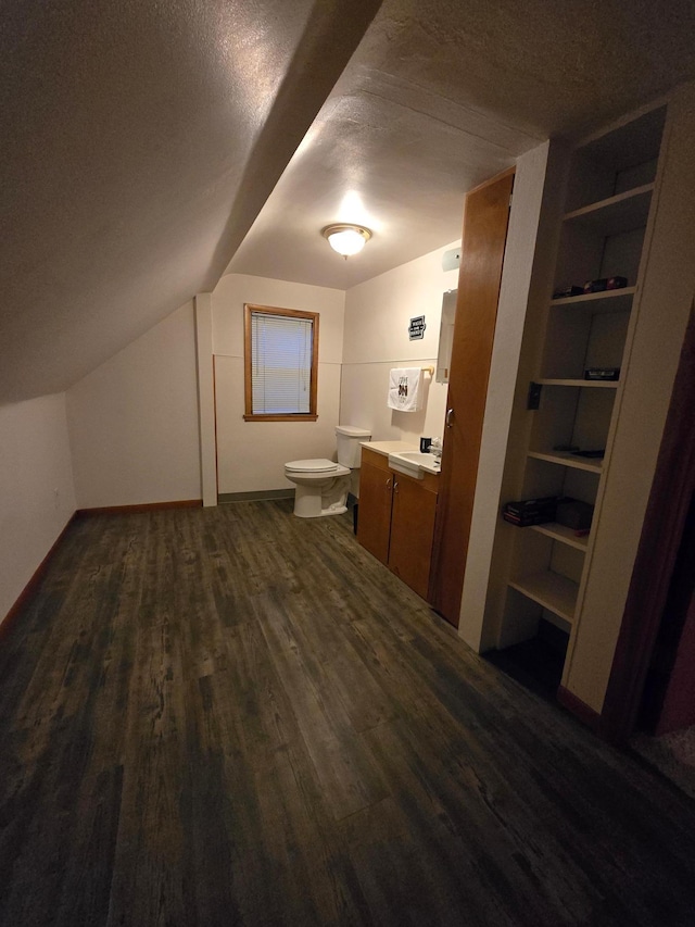 1014 3rd Ave SW, Pipestone, MN 56164 - bathroom featuring a textured ceiling, vanity, toilet, wood finished floors, and lofted ceiling