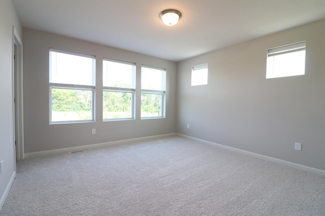 spare room with baseboards and carpet