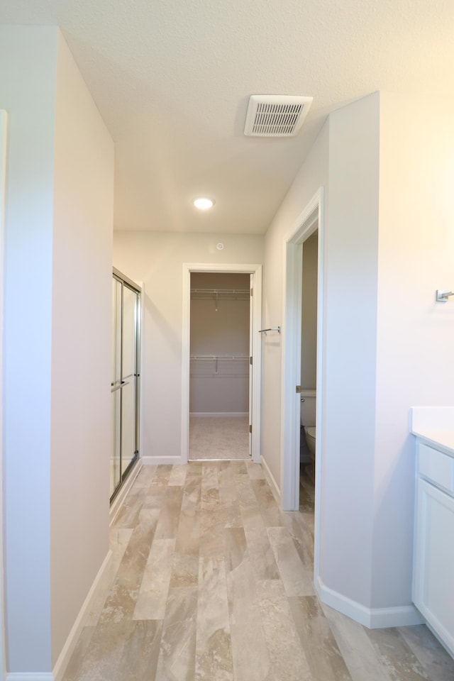 hallway featuring recessed lighting, visible vents, and baseboards