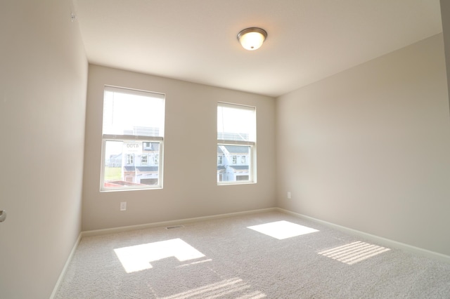 carpeted empty room featuring baseboards