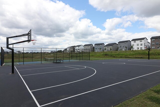 view of sport court with community basketball court, fence, and a residential view