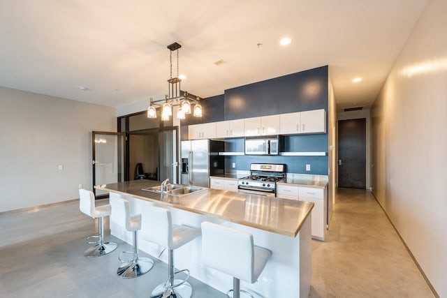 kitchen featuring concrete floors, white cabinetry, stainless steel appliances, and a sink