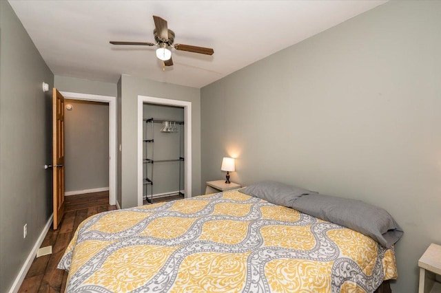 bedroom featuring a closet, dark wood-style flooring, ceiling fan, and baseboards