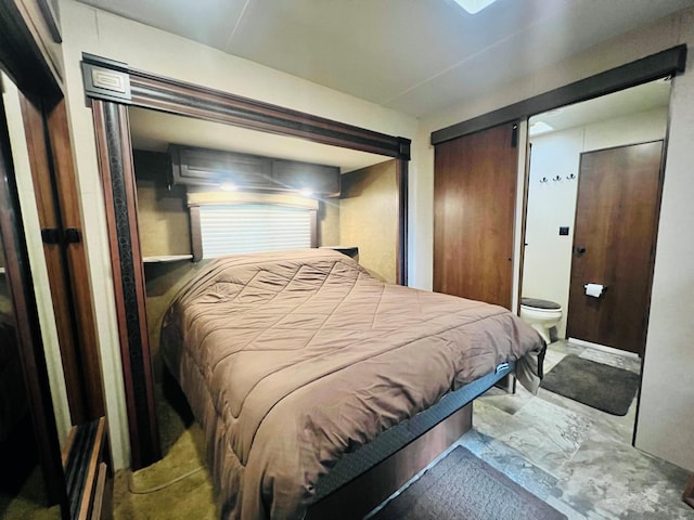 bedroom featuring connected bathroom and a barn door