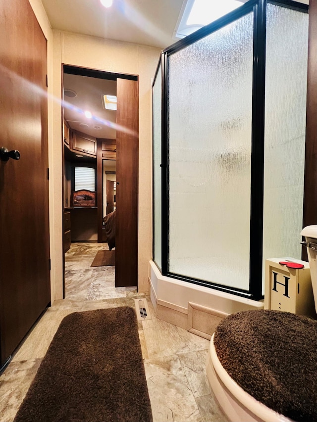 bathroom featuring a stall shower and marble finish floor