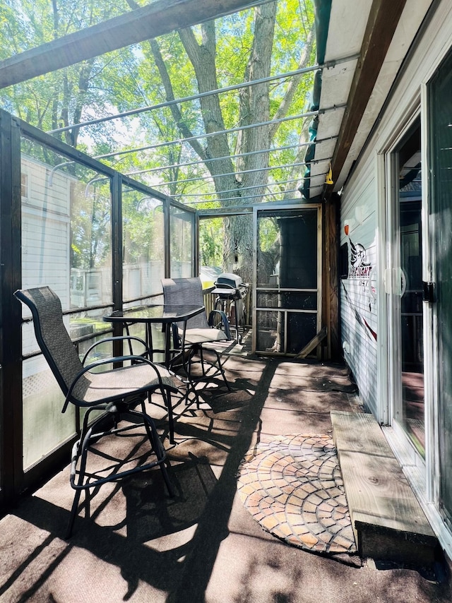 sunroom / solarium featuring a wealth of natural light and outdoor dining area