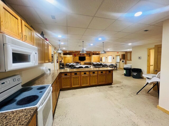 kitchen with open floor plan, white appliances, a peninsula, brown cabinetry, and a drop ceiling