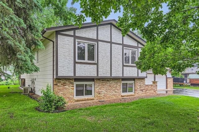 211 Mckinley St, Anoka, MN 55303 - view of side of property featuring a yard, stone siding, and central AC