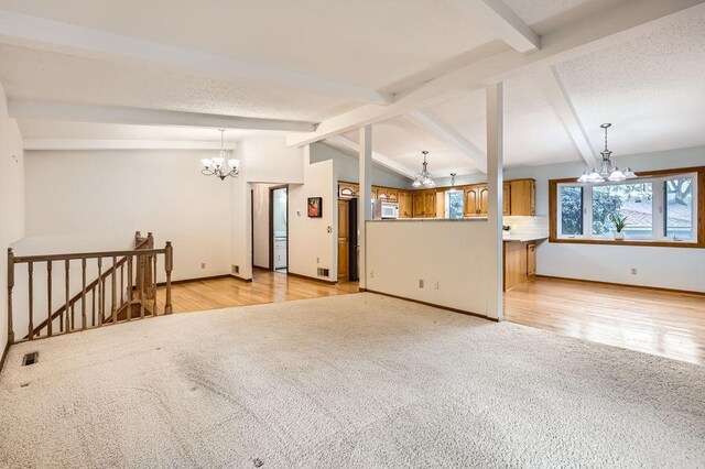211 Mckinley St, Anoka, MN 55303 - unfurnished living room featuring a chandelier, light colored carpet, baseboards, and light wood-type flooring