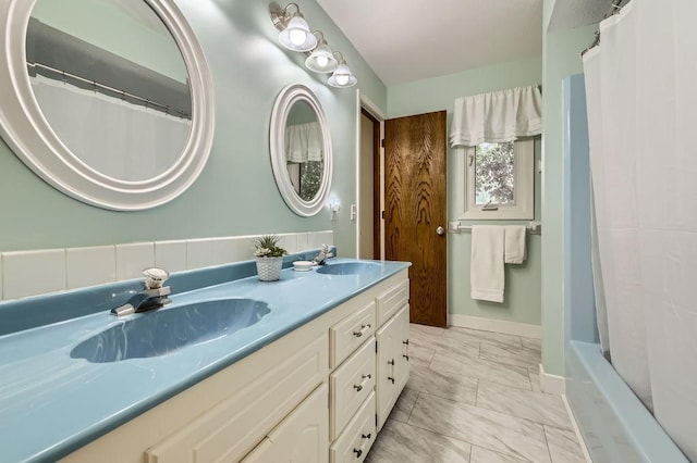 211 Mckinley St, Anoka, MN 55303 - bathroom with double vanity, marble look tiles, and shower / bathtub combination with curtain