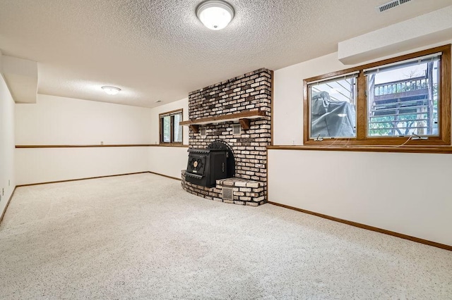 211 Mckinley St, Anoka, MN 55303 - unfurnished living room featuring a wood stove, a textured ceiling, and baseboards
