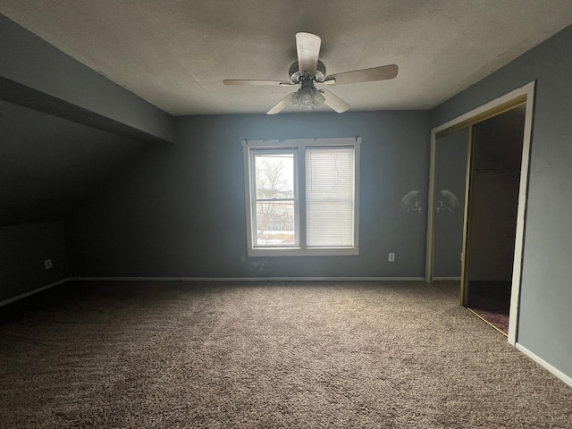 unfurnished bedroom featuring a closet, baseboards, a textured ceiling, a ceiling fan, and carpet