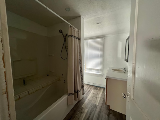 full bathroom with a textured ceiling, wood finished floors, shower / bath combo with shower curtain, and vanity
