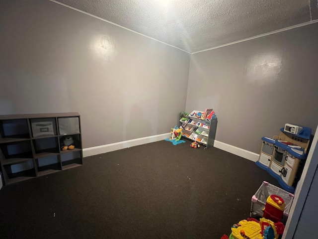 rec room with a textured ceiling, carpet flooring, and baseboards