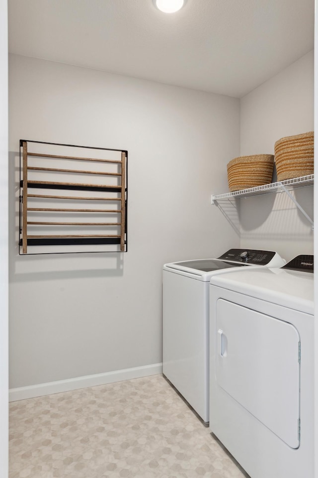 laundry room featuring laundry area, separate washer and dryer, baseboards, and light floors