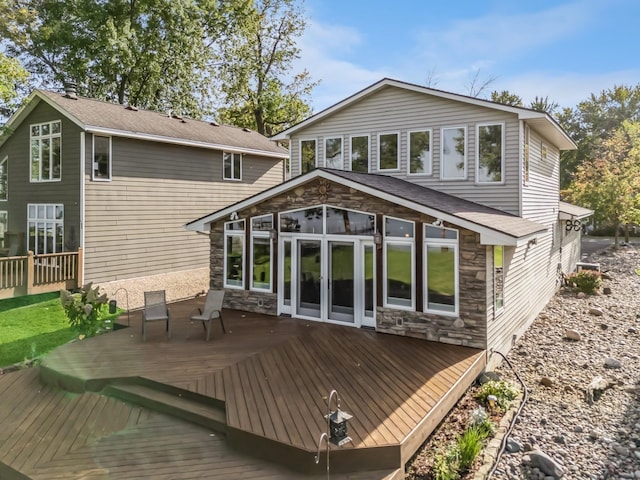 1867 Beach Dr SE, Forest Lake, MN 55025 - rear view of house featuring stone siding, a sunroom, and a deck