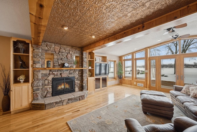 1867 Beach Dr SE, Forest Lake, MN 55025 - living room featuring a ceiling fan, a fireplace, wood finished floors, and an ornate ceiling
