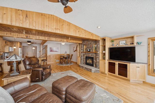 1867 Beach Dr SE, Forest Lake, MN 55025 - living area with ceiling fan, lofted ceiling, wood finished floors, a textured ceiling, and wood walls