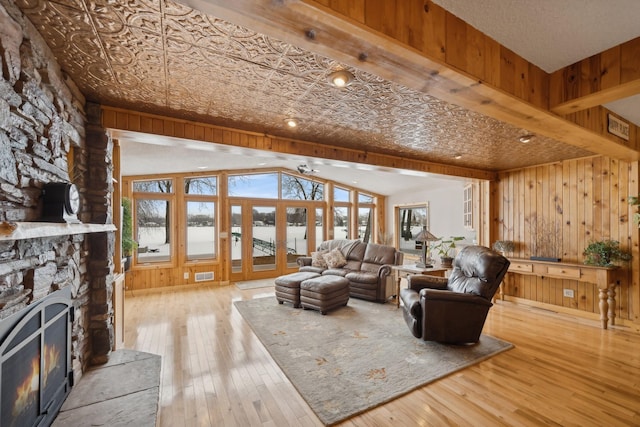 1867 Beach Dr SE, Forest Lake, MN 55025 - living area featuring a stone fireplace, wooden walls, hardwood / wood-style floors, and a water view