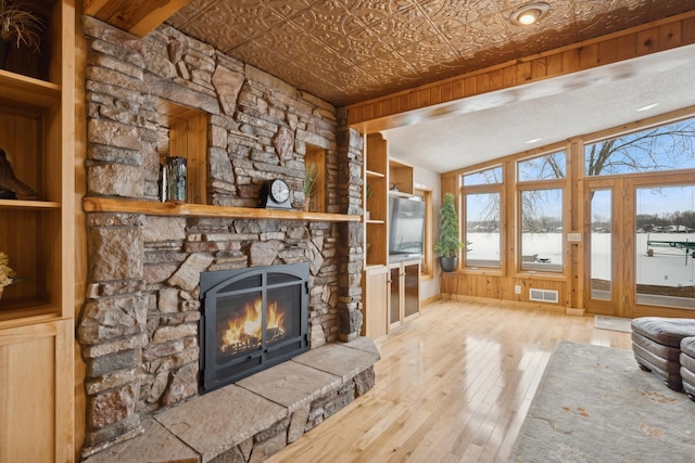 1867 Beach Dr SE, Forest Lake, MN 55025 - unfurnished living room with a stone fireplace, wood-type flooring, and an ornate ceiling