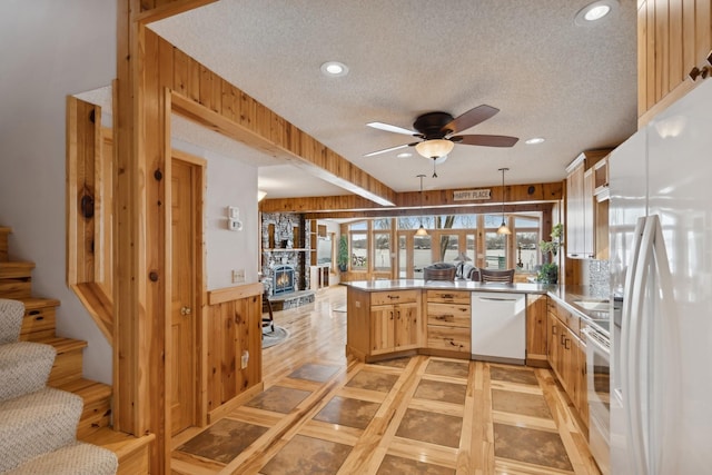 1867 Beach Dr SE, Forest Lake, MN 55025 - kitchen with white appliances, a peninsula, a textured ceiling, ceiling fan, and light brown cabinetry