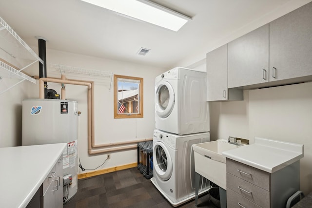 1867 Beach Dr SE, Forest Lake, MN 55025 - washroom featuring stacked washer / dryer, water heater, cabinet space, and baseboards