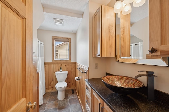 1867 Beach Dr SE, Forest Lake, MN 55025 - full bathroom with a wainscoted wall, toilet, a textured ceiling, vanity, and wood walls