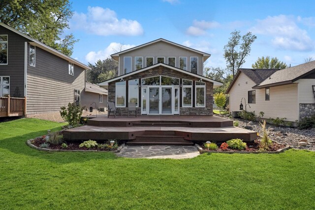 1867 Beach Dr SE, Forest Lake, MN 55025 - back of property with stone siding, a wooden deck, and a lawn
