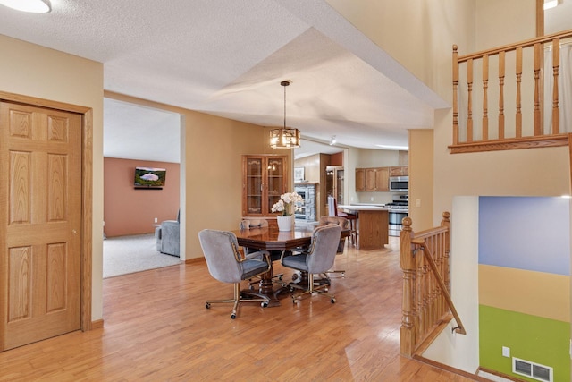 34115 Malmberg Ave, Chisago Lake Twp, MN 55045 - dining room featuring light wood finished floors, a textured ceiling, and a chandelier