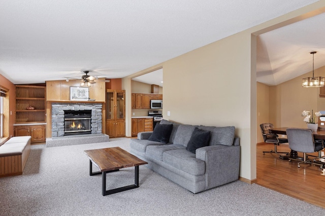 34115 Malmberg Ave, Chisago Lake Twp, MN 55045 - living area with light carpet, ceiling fan, a fireplace, a chandelier, and vaulted ceiling