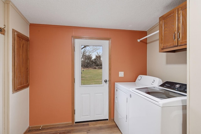 34115 Malmberg Ave, Chisago Lake Twp, MN 55045 - laundry room featuring cabinet space, washer and clothes dryer, light wood-type flooring, and a textured ceiling