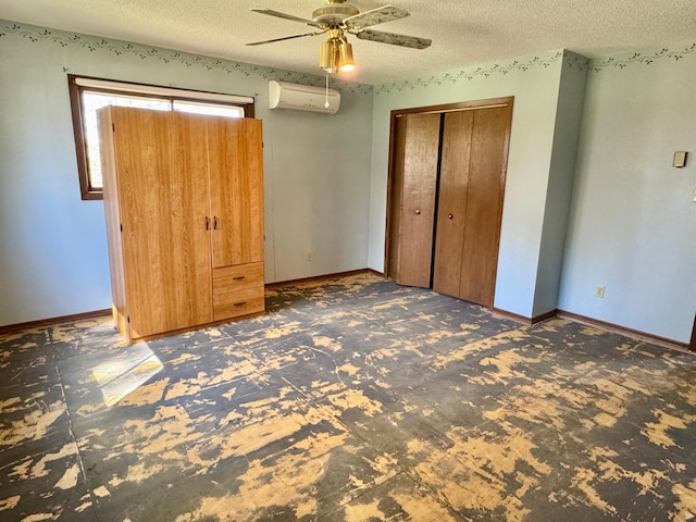 unfurnished bedroom with carpet, a wall mounted AC, a textured ceiling, a ceiling fan, and baseboards
