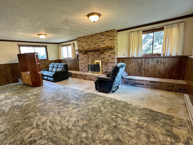 living room featuring wooden walls, a wainscoted wall, a textured ceiling, a brick fireplace, and ornamental molding