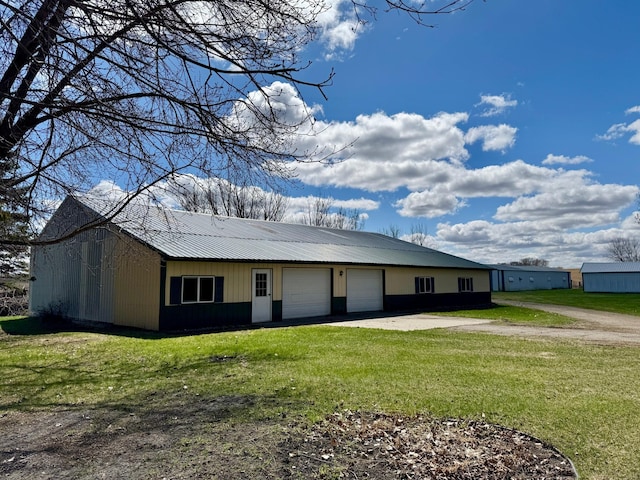 view of front of property featuring a front lawn, metal roof, and driveway