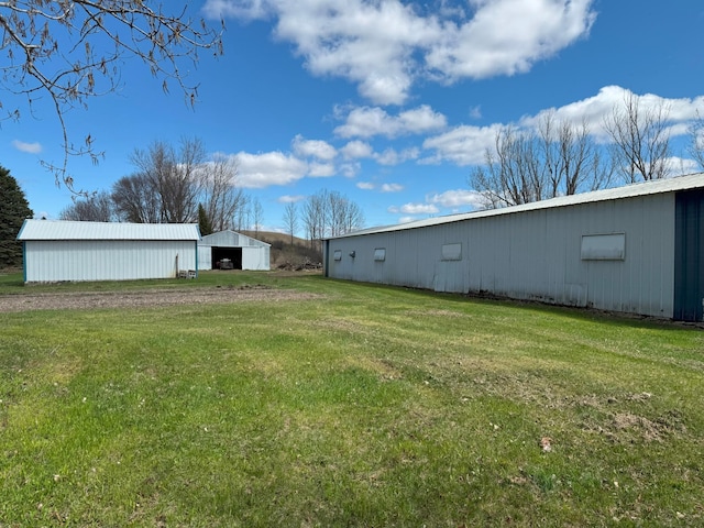 view of green lawn featuring an outbuilding and a detached garage