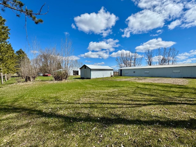 view of green lawn with an outbuilding and an outdoor structure