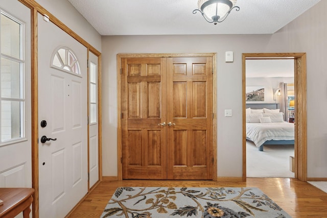 foyer entrance featuring baseboards and light wood-type flooring