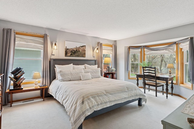 bedroom featuring a textured ceiling, multiple windows, and light carpet