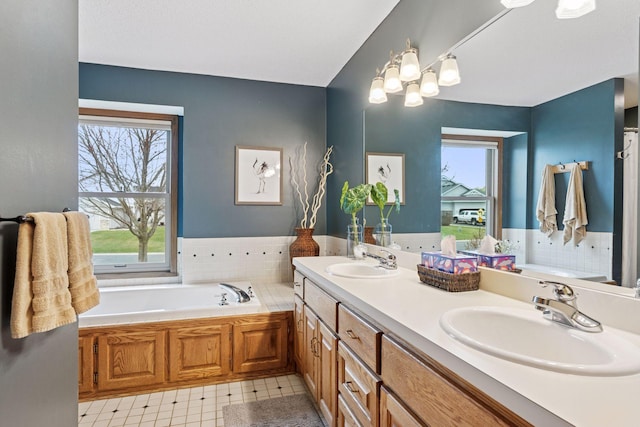 bathroom featuring plenty of natural light, a bath, and a sink