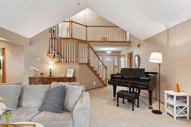 living room featuring stairway, high vaulted ceiling, visible vents, light carpet, and baseboards