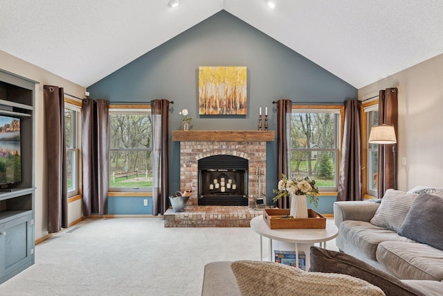carpeted living area with plenty of natural light, baseboards, high vaulted ceiling, and a brick fireplace