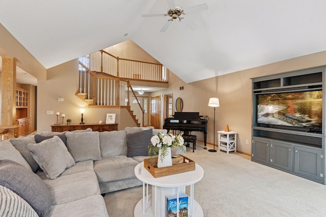 carpeted living area with stairway, visible vents, ceiling fan, baseboards, and high vaulted ceiling