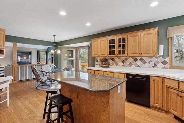 kitchen featuring a textured ceiling, dishwasher, and light wood-style flooring