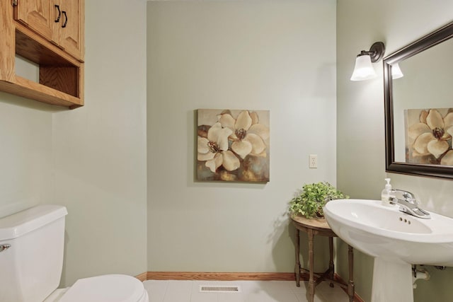 bathroom featuring baseboards, visible vents, toilet, and tile patterned flooring