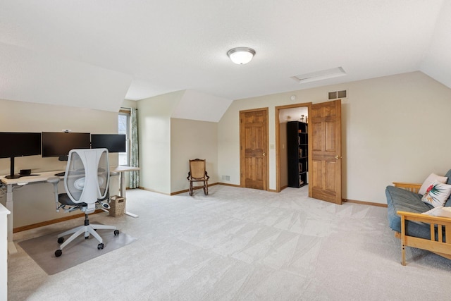 office with baseboards, visible vents, light colored carpet, and vaulted ceiling