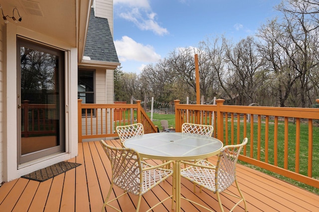 deck with outdoor dining space and a yard