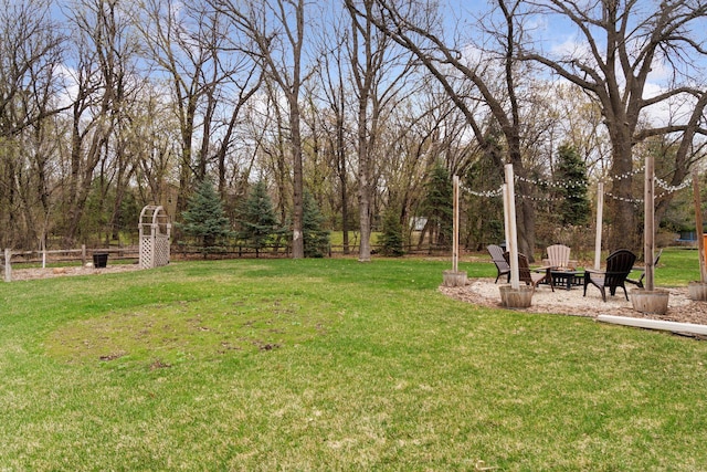 view of yard featuring fence and a fire pit