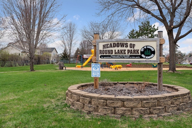 community / neighborhood sign with fence and a lawn