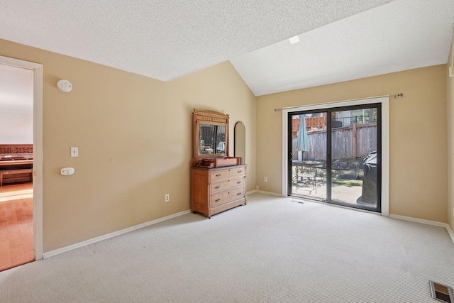 unfurnished room with light colored carpet, lofted ceiling, baseboards, and a smoke detector